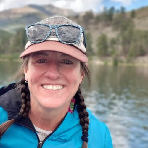 Cat Gruener, Trail Manager, smiling alongside the river